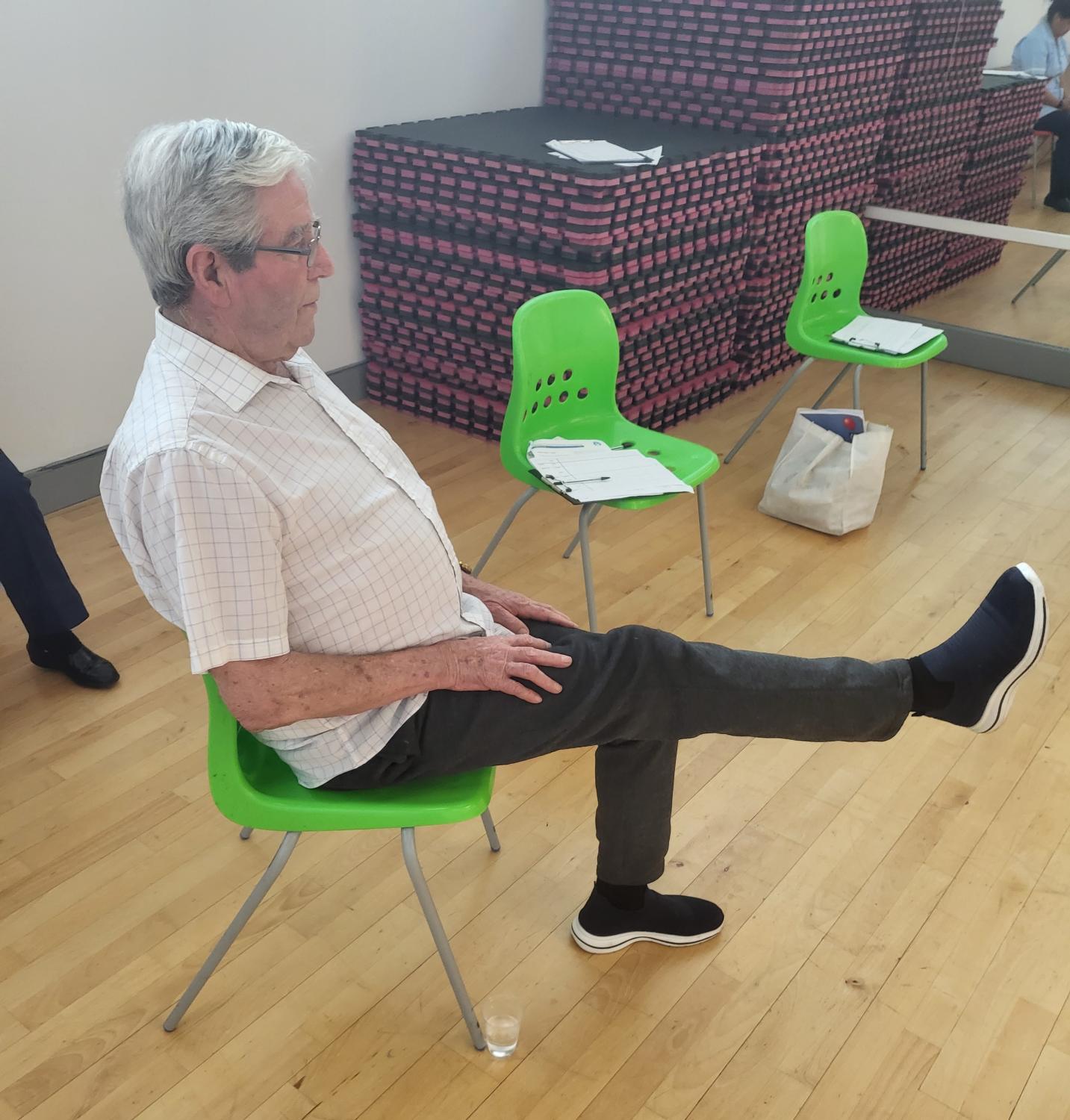 Rehab patient sitting down stretching leg exercise